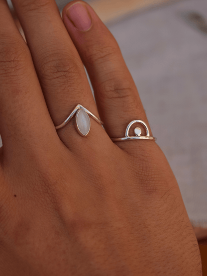 sterling silver ring on hand with moonstone ring next to it